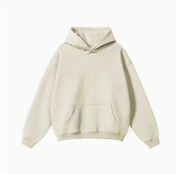 Man wearing a grey heavyweight cotton terry hooded sweater with a loose fit and drop-shoulder sleeves.