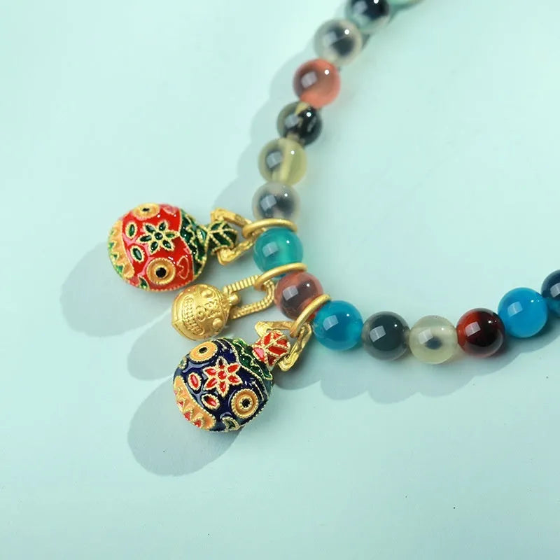 Handmade women's agate bracelet with coloured glaze copper coins in a snake chain, showing fu character or swallowing gold beast motifs.