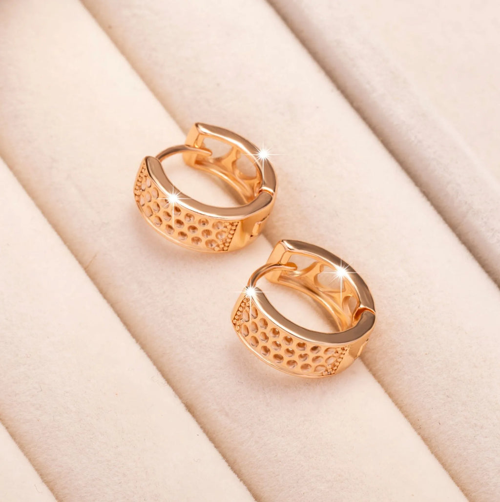 A pair of rose gold hollow heart-shaped earrings for women on a white background.