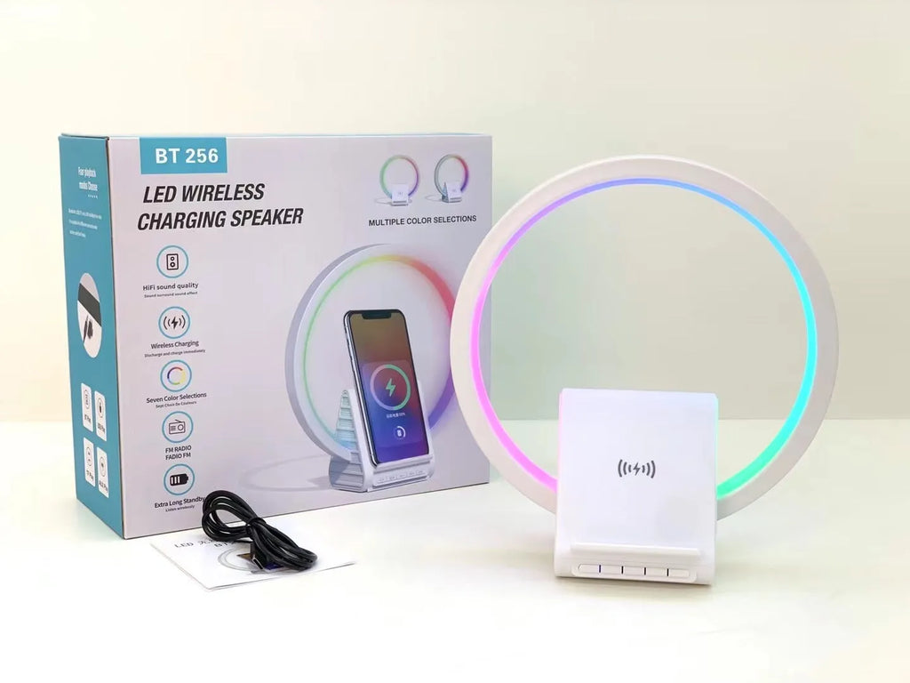 White rectangular smart Bluetooth speaker with integrated wireless charging pad and ambient light on a desk