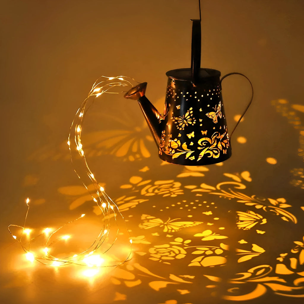 Tapered iron solar garden lantern with butterfly pattern emitting warm white light.