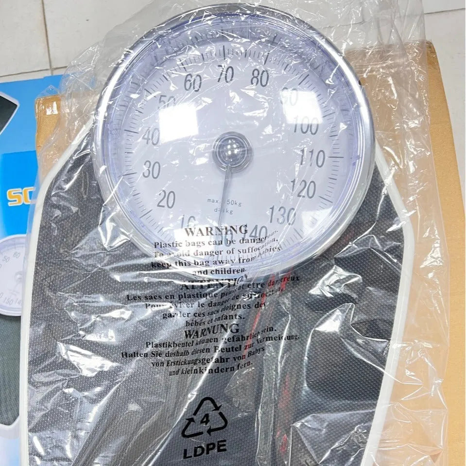 Black mechanical bathroom scale with large analogue dial showing weight measurements