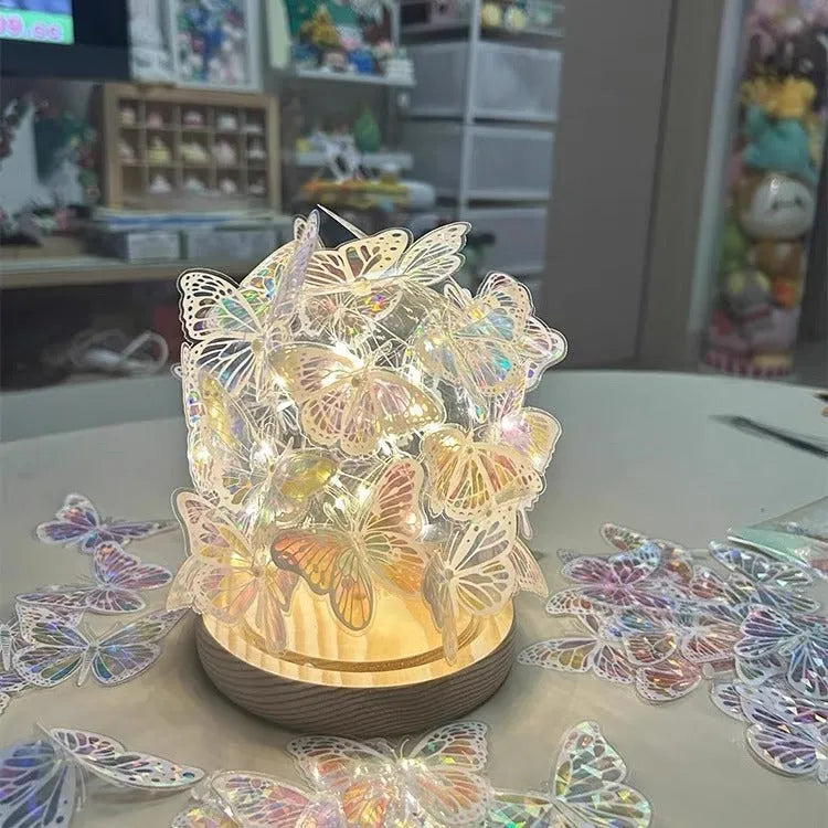 Butterfly-shaped night lamp with glass lampshade on raw wood base