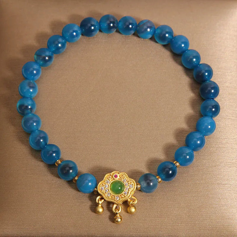 Blue sugar heart agate safety lock pendant on a crystal women's bracelet with alloy-set stones.
