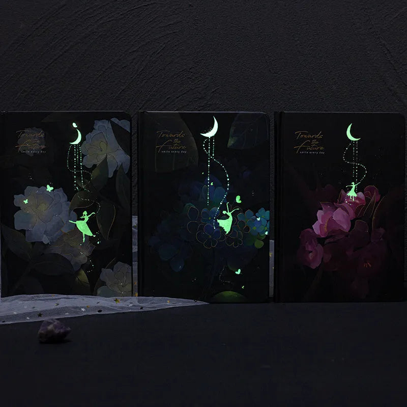 A5 scrapbook notebook with luminous cover open to show colour illustration pages, in purple colour option.
