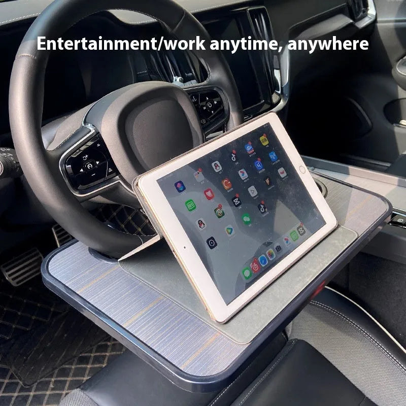 Black ABS plastic car steering wheel laptop stand with foldable cup holder on a grey steering wheel
