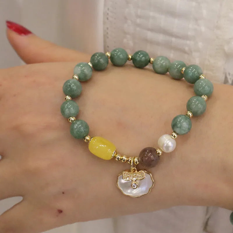 Green jade shell bracelet with adjustable silver chain on a wrist.