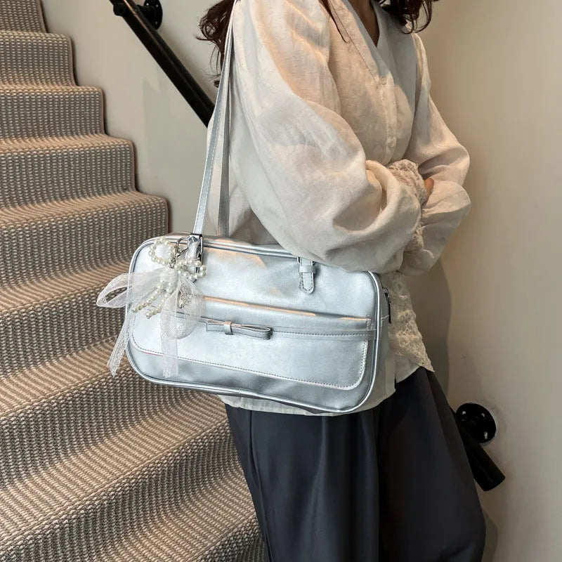 Single-shoulder flap bag in PU leather with bow stitching details and horizontal square shape