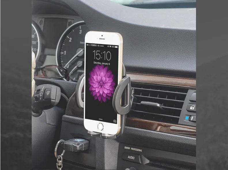 Black universal car air vent mobile phone holder mounted on a car vent, holding a smartphone.