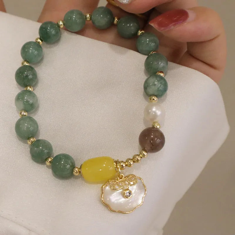 Green jade shell bracelet with adjustable silver chain on a wrist.