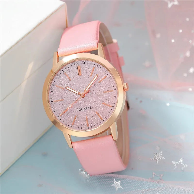 Women's pink quartz watch set with faux leather strap and bracelet on a light background