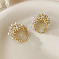Gold-coloured copper flower basket earrings with small rice-shaped beads and pearl inlay detail.