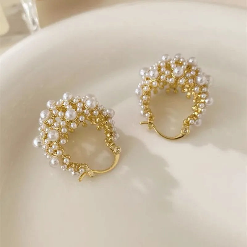 Gold-coloured copper flower basket earrings with small rice-shaped beads and pearl inlay detail.