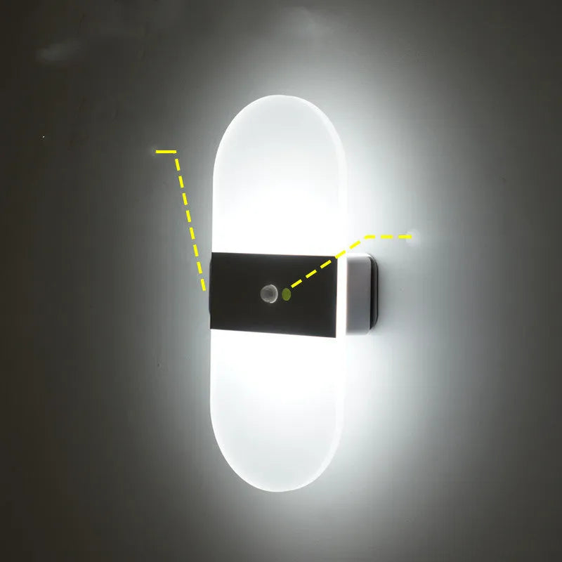 Magnetic rechargeable wall lamp in arc style, black finish, with warm light on a metal bedside shelf