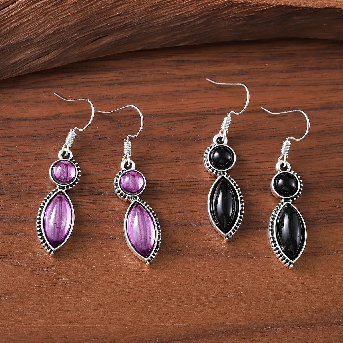 A pair of geometric vintage pendant earrings in black and purple colours with a bohemian style.