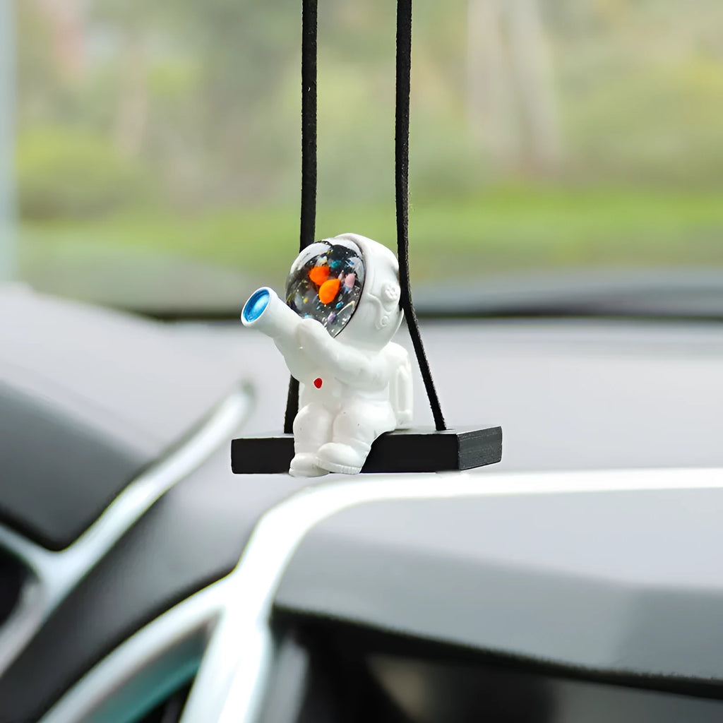 Resin astronaut car pendant showing five cartoon designs including telescope and flag-holding astronauts