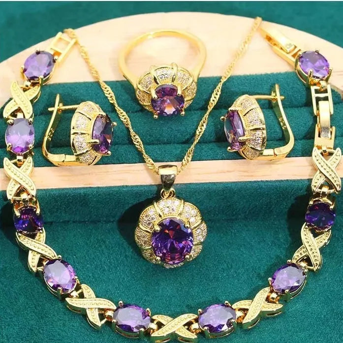 Gold-coloured jewellery set with coloured cubic zirconia stones, showing necklace, earrings, ring, and bracelet.