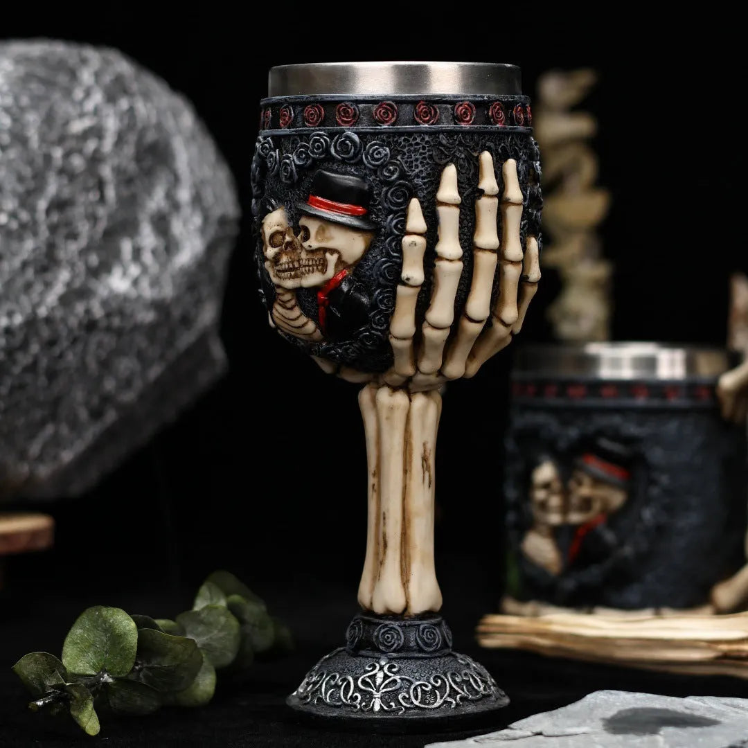 A pair of stainless steel wine glasses with a detailed red human skeleton pattern on a black background.