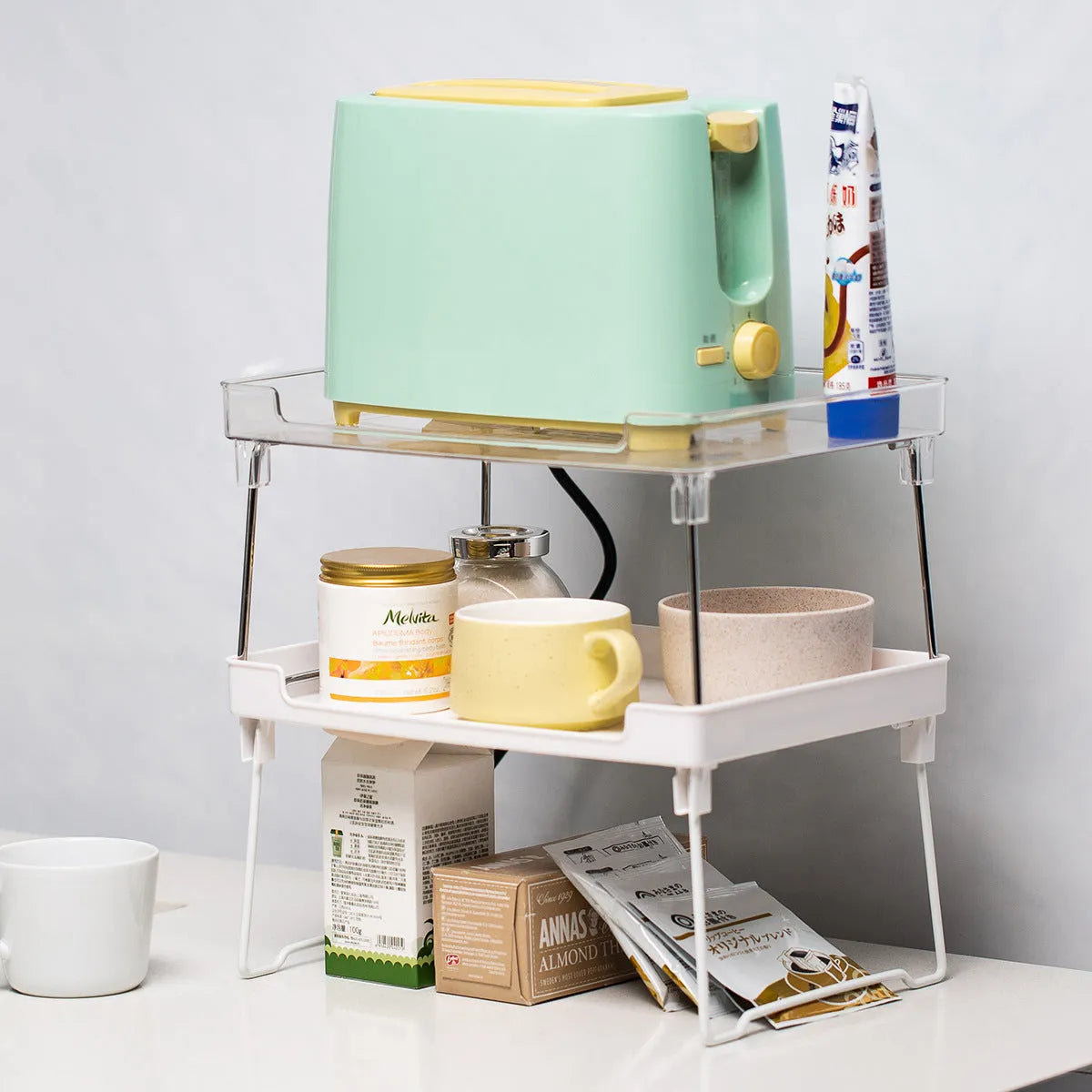 White and transparent plastic kitchen shelf organiser rack for countertop or cupboard storage