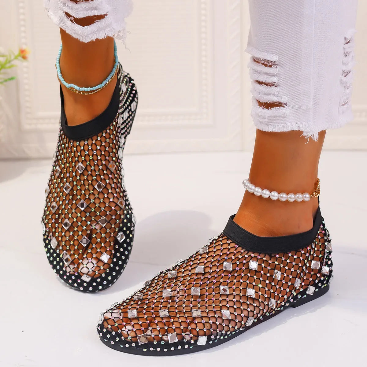 Women's flat sandals with mesh upper, colourful rhinestone decoration, and a rubber sole.