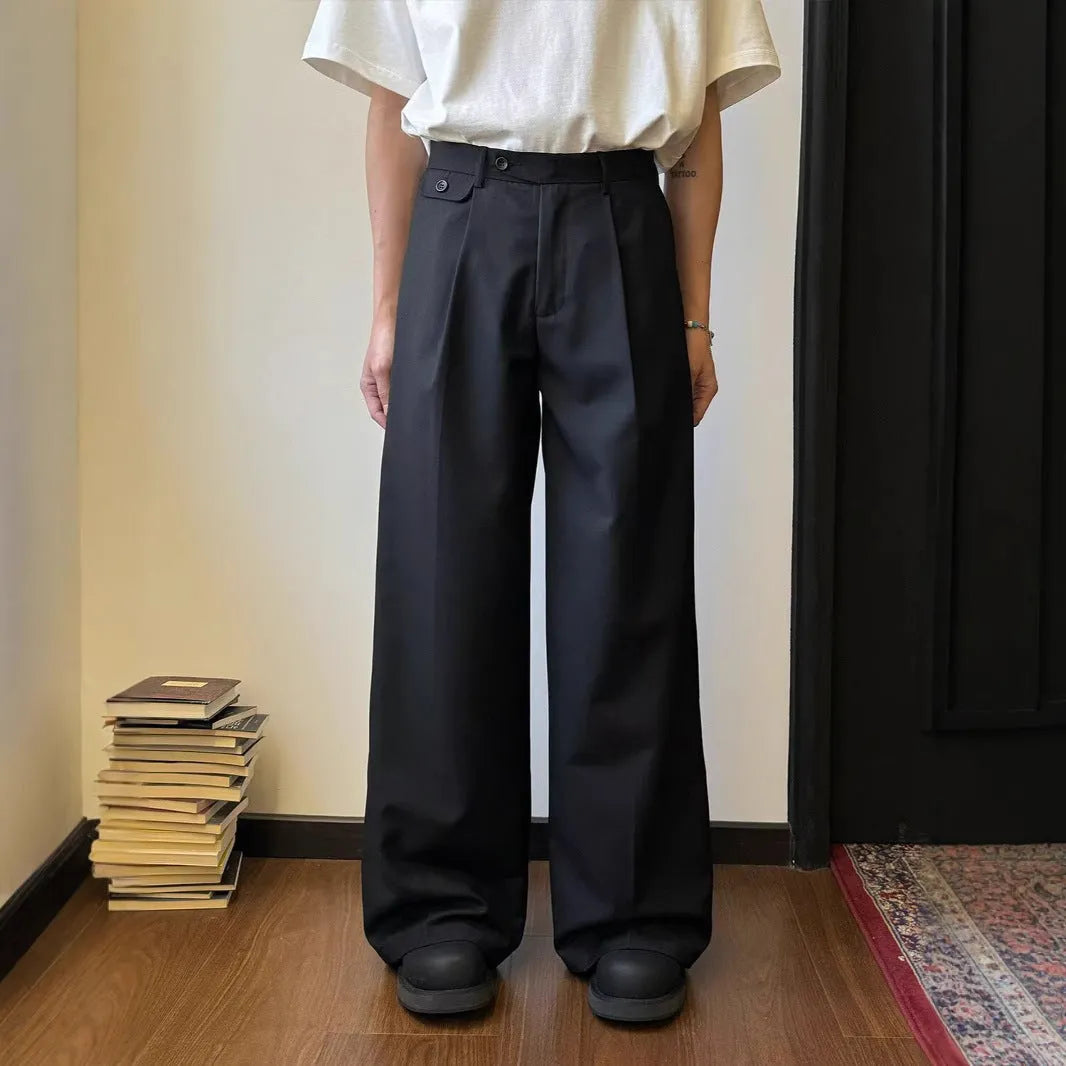 Men's brown straight-leg wide-drape trousers on a hanger, showing loose fit.