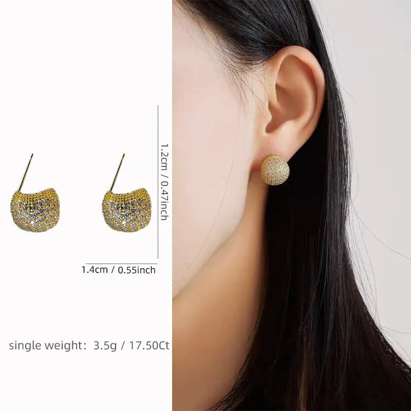 Drop-shaped geometric golden beans and diamond ear clip earrings in gold and white colours.