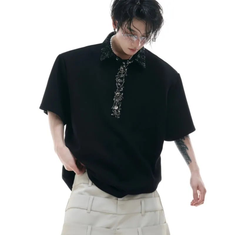 Men's black loose-fit polo t-shirt with square collar, pin, and heavy embroidery sequin detail on the chest.