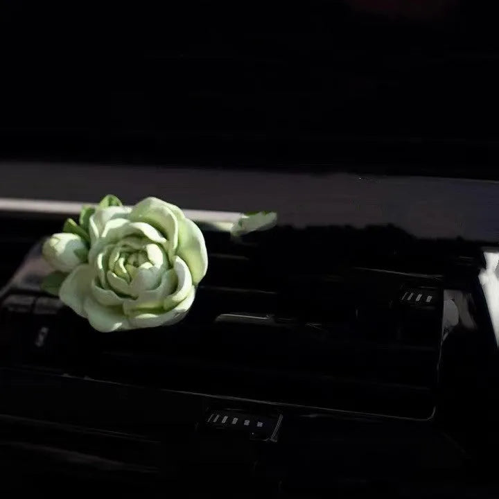 Solid gypsum car air freshener diffuser in air vent with jasmine fragrance oil.