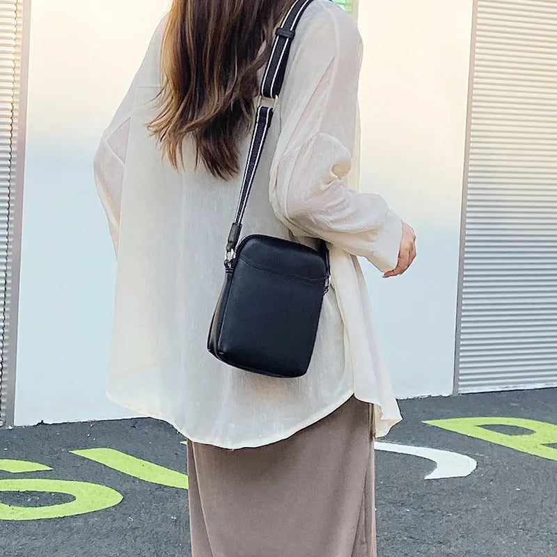Small solid colour PU leather crossbody bag for women in black, shown with shoulder strap.