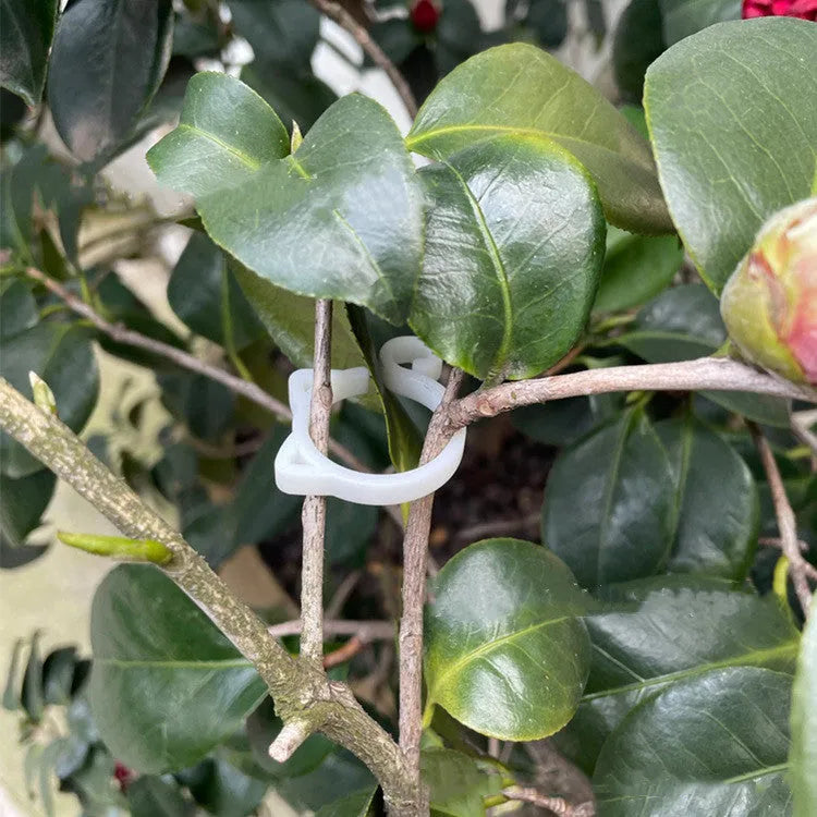 Decorative red plastic cat-shaped clip for gardening plant support.