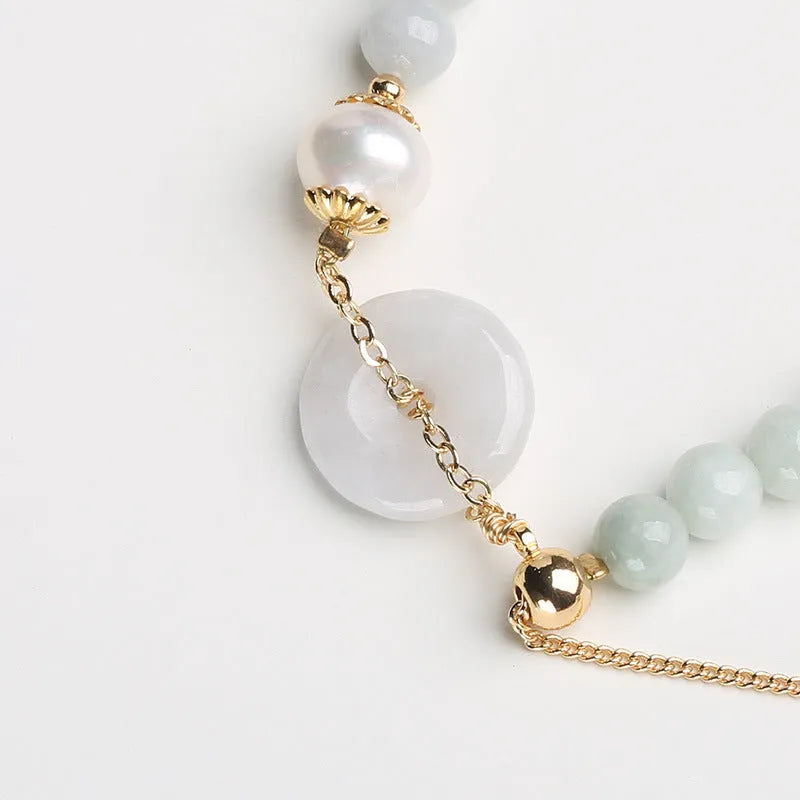 Natural jade bracelet with peace buckle fastener and white pearl accents, geometric pendant design