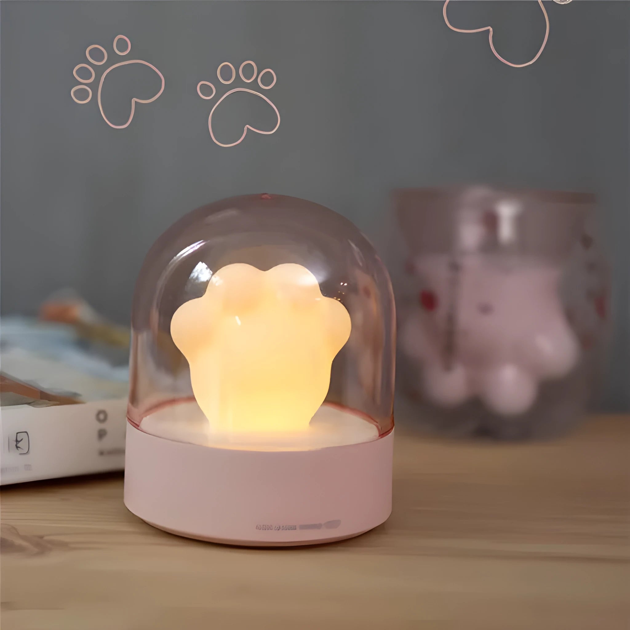 Grey cat paw shaped USB rechargeable night light and music box lamp on a desktop.