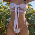 Women's lace-up front swimsuit with high-leg split and built-in chest pad, shown in a floral print.