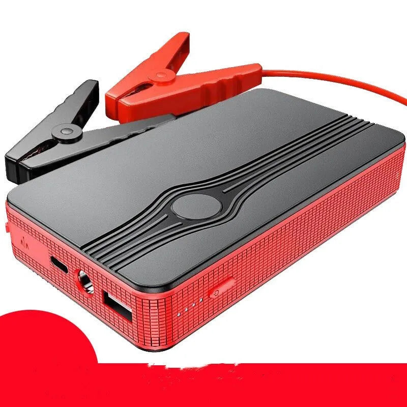 Red K4-E car jump starter power bank with display, shown next to a data cable on a dark surface.