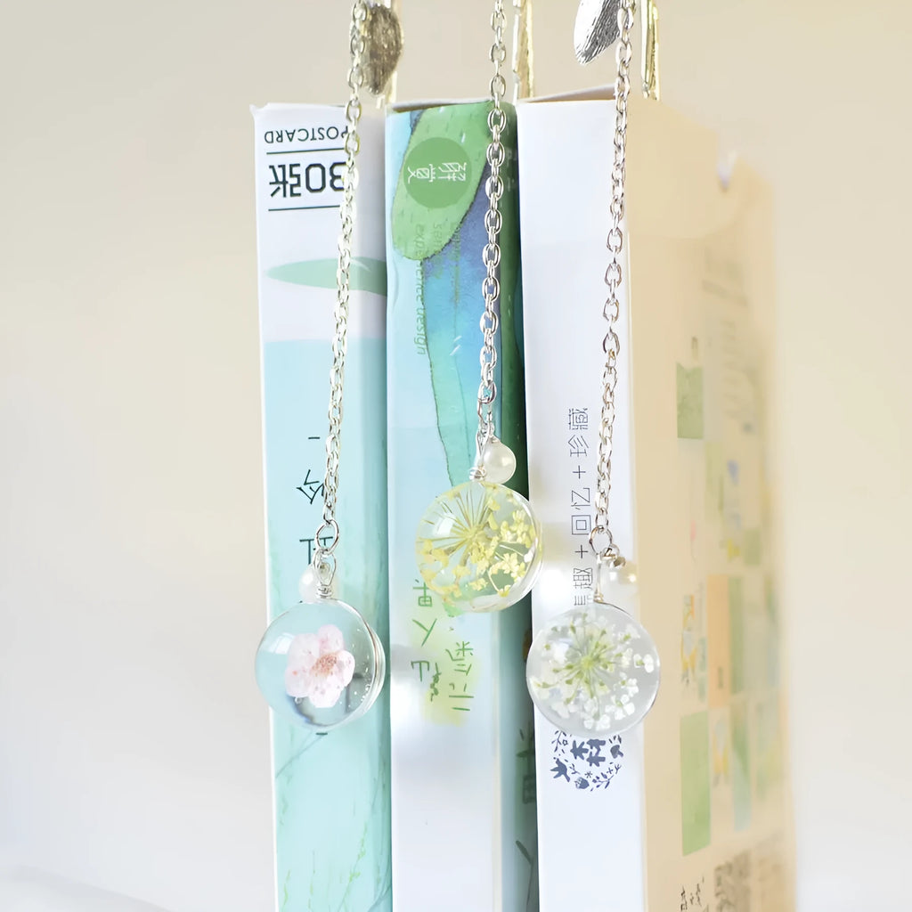 Dried flower specimen encased in metal alloy bookmark pendant measuring 12cm by 2cm