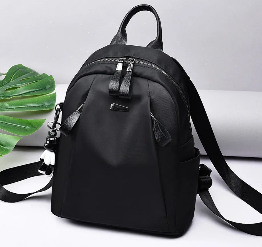 Medium-sized grey Oxford cloth rucksack with double straps, shown open to reveal internal phone and ID pockets.