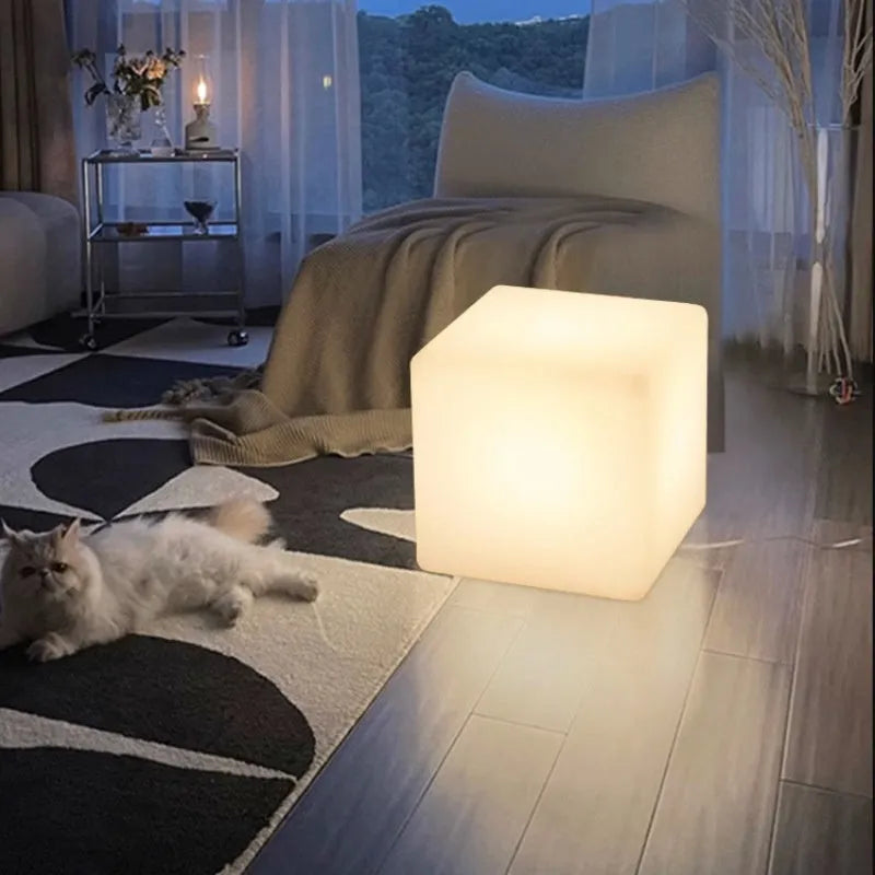 Modern white LED cube stool light outdoors, showing flat top and clean design.