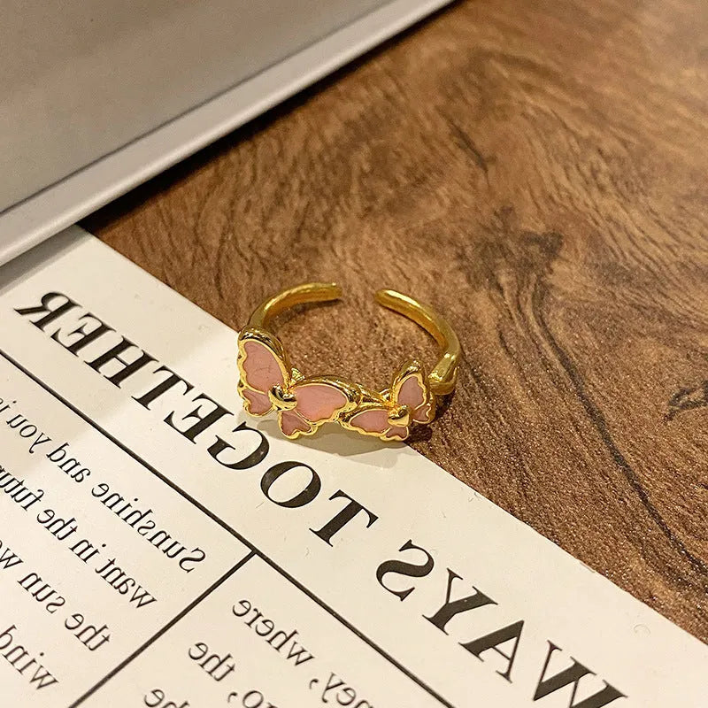 Copper butterfly women's ring with oil-drip finish showing open-loop design