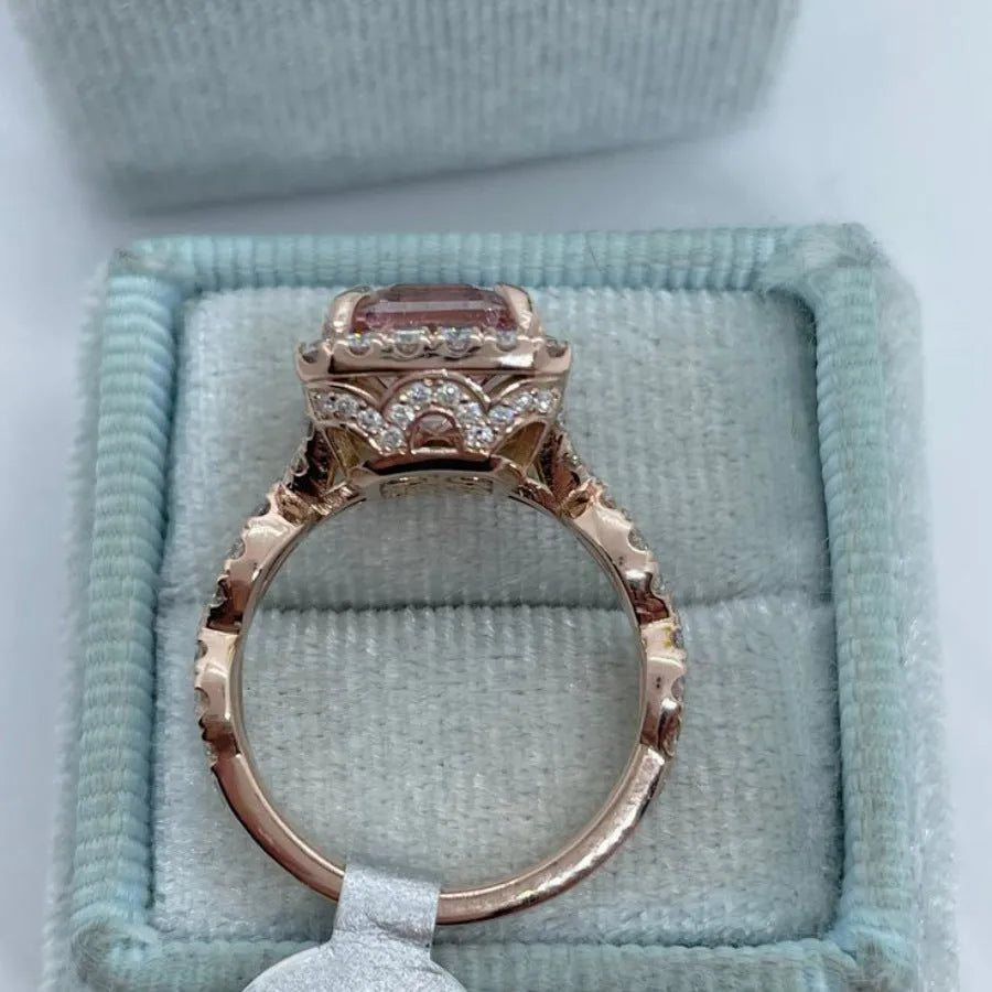 A geometric-shaped rose gold alloy ring on a plain background.