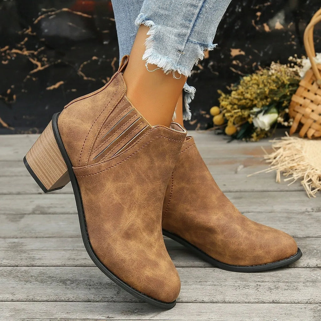 Women's black ankle boots with pointed toe and thick square heel on a rubber sole