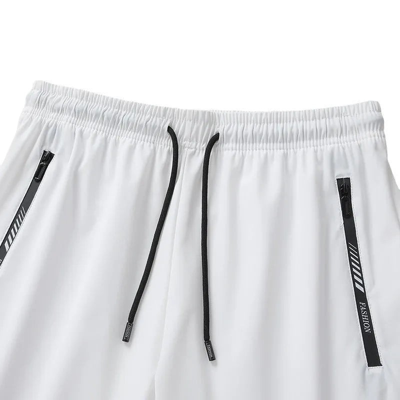 Man wearing black loose-fit quick-drying nylon sports shorts with a five-inch length.