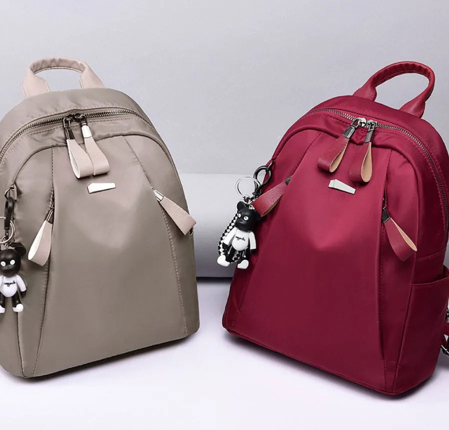 Medium-sized grey Oxford cloth rucksack with double straps, shown open to reveal internal phone and ID pockets.