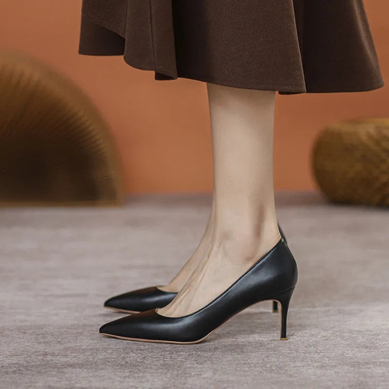 Black pointed toe stiletto high heel pump shoe with a low cut, shown on a white background.