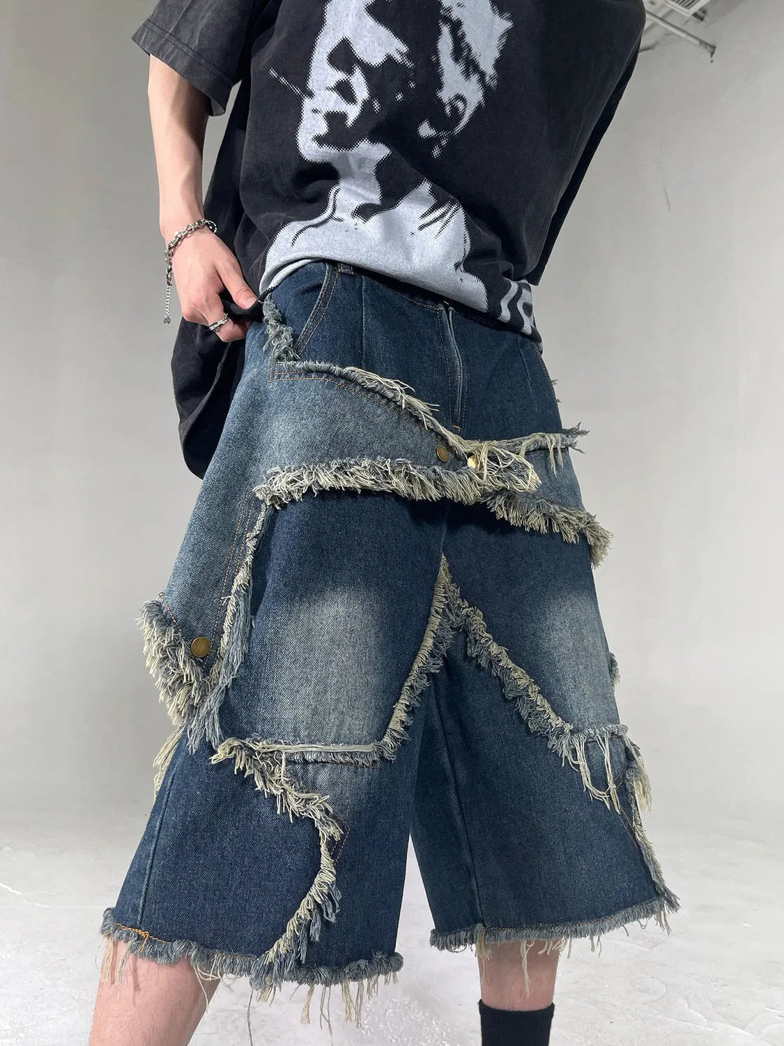Blue denim shorts with frayed five-pointed star design and loose fit
