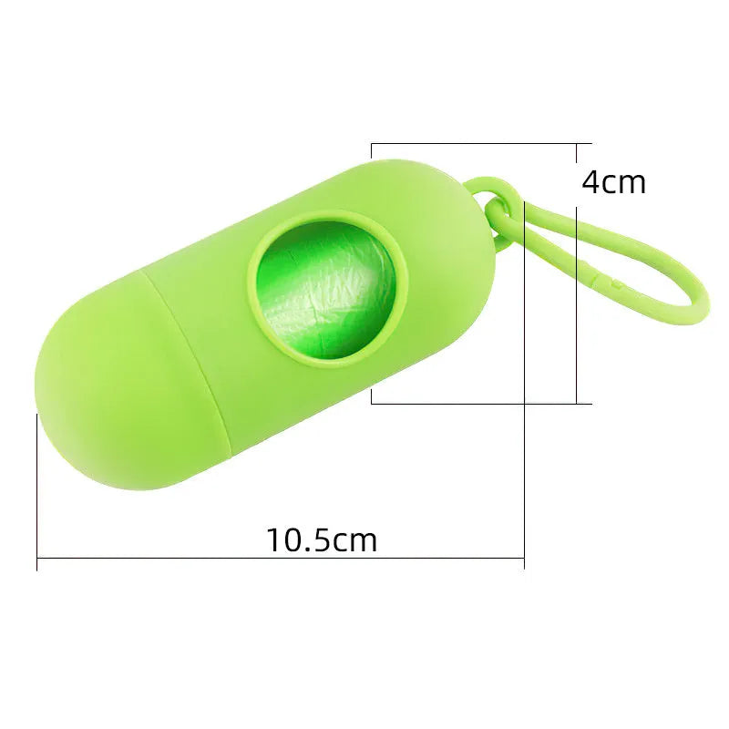 A compact black dog poop bag holder with a side hook and Velcro strap, shown next to a roll of waste bags.