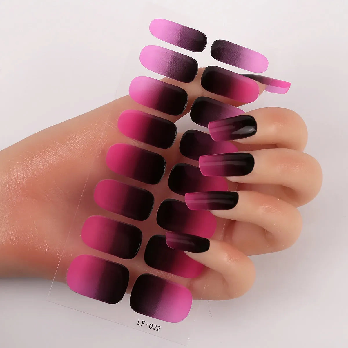 Full sheet of nail art stickers showing sixteen small designs including cross, rose, tulip, and leopard print patterns.