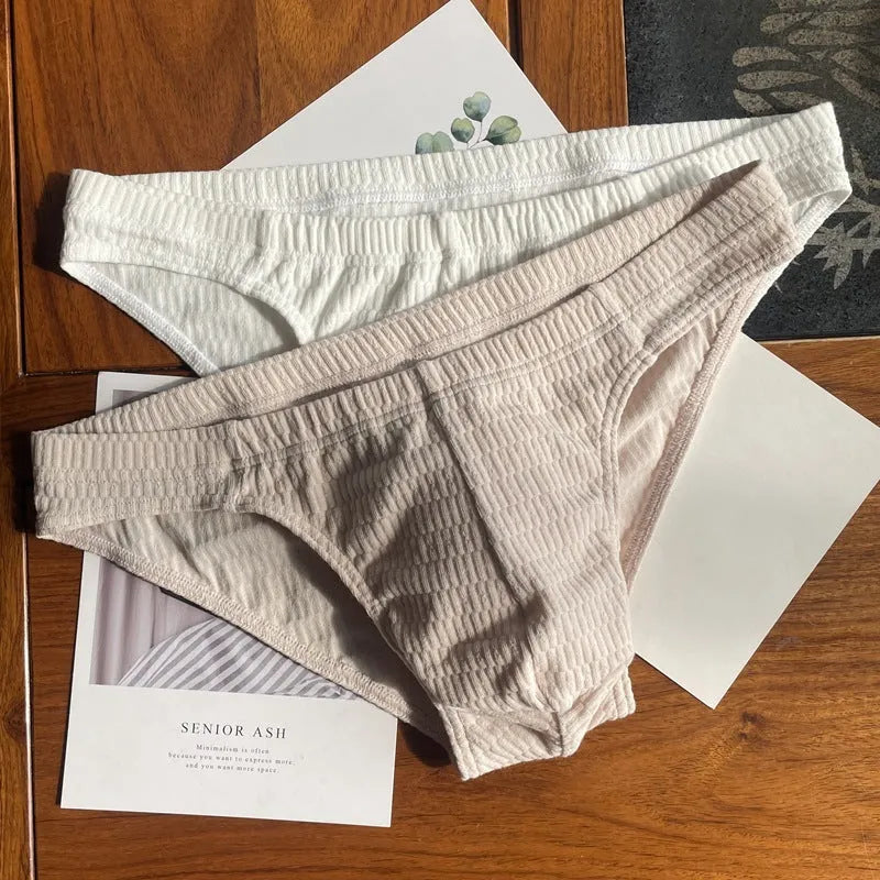 Men's solid colour cotton triangle briefs in apricot, shown from the front on a mid-waist fit model.