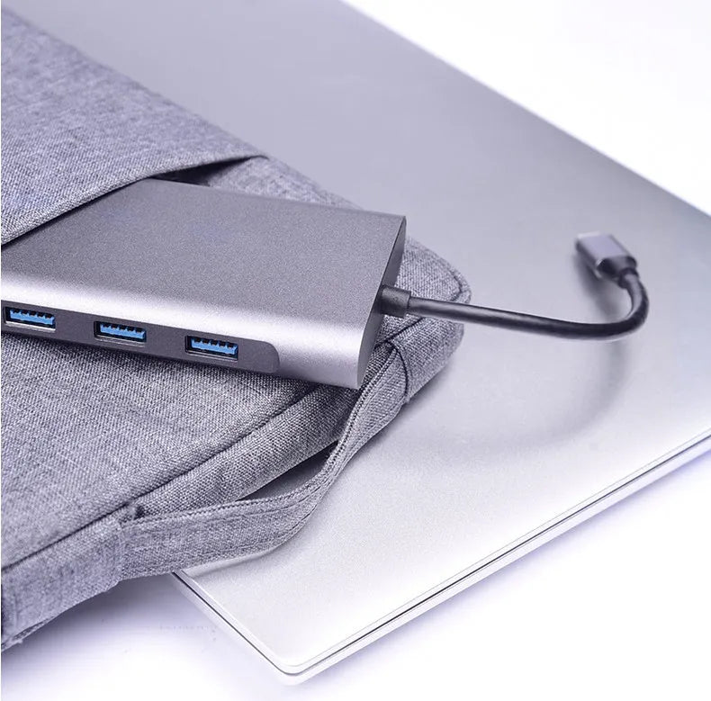 Silver 10-in-1 USB-C docking hub for MacBook with multiple ports including HDMI, USB, and SD card slots.