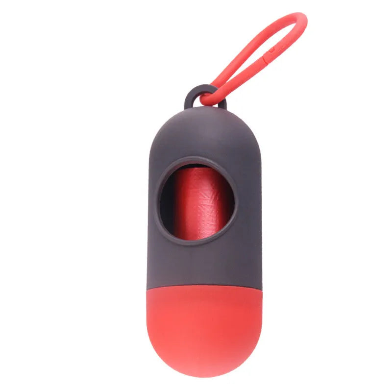 A compact black dog poop bag holder with a side hook and Velcro strap, shown next to a roll of waste bags.