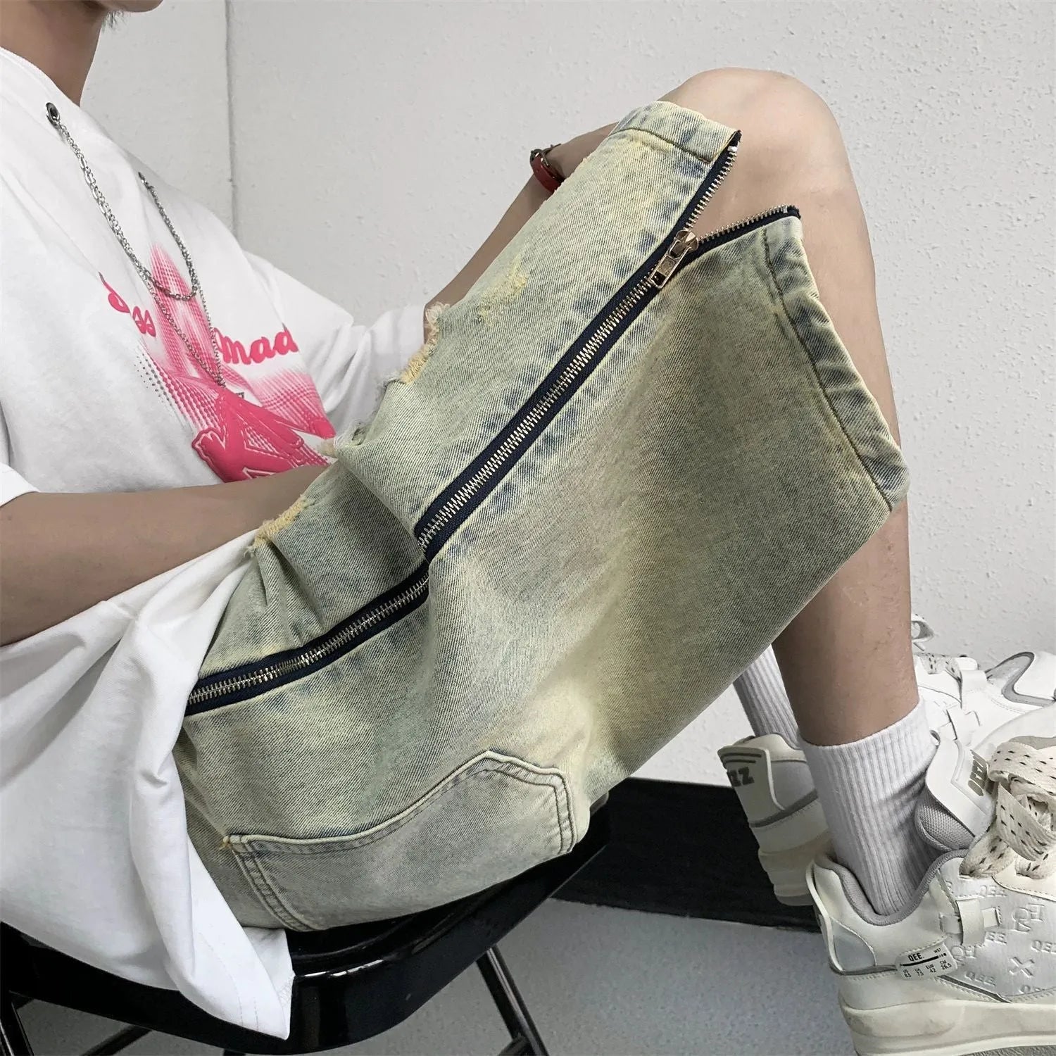 Blue retro denim shorts for men with ripped detail, loose five-points fit, and button fly closure.